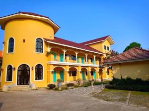 a large yellow building with a red roof at Wangpla Villa Resort in Nakhon Sawan