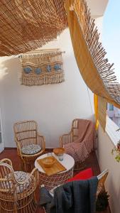シラクーサにあるTraditional Sicily house design revisitedの籐の椅子とテーブル、窓が備わる客室です。