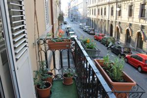a balcony with potted plants on a city street at B&B Empire 1970 in Trieste