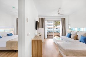 a bedroom with a bed and a living room with a couch at Metropolitan Juka Playa in Playa de Palma