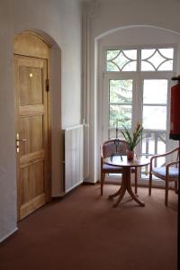 um quarto com uma porta, uma mesa e uma janela em Villa Wilisch em Amtsberg