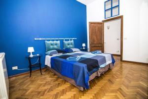 a blue bedroom with a bed and a blue wall at Tiberim Apartment Trastevere 9 in Rome
