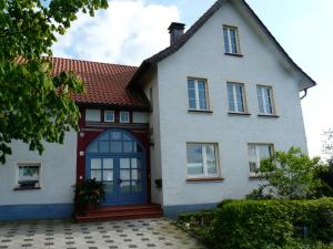 una casa blanca con una puerta azul en Haus mit Aussicht, en Horn-Bad Meinberg
