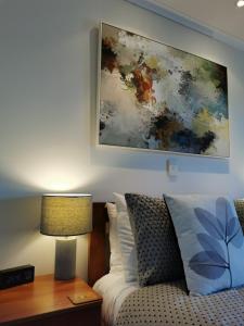 een slaapkamer met een bed en een schilderij aan de muur bij ASURE Ascot Motor Inn in Taupo