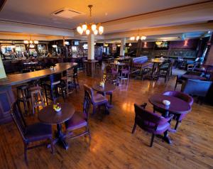 een restaurant met tafels en stoelen en een bar bij Treacys West County Conference and Leisure Centre in Ennis