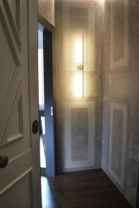 een hal met een deur en een licht aan de muur bij PALAZZO DELLE SIRENE Deluxe Apartment & Boutique Rooms in Levanto