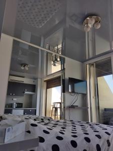 1 dormitorio con 1 cama con edredón blanco y negro en Clubber Naturiste Design en Cap d'Agde