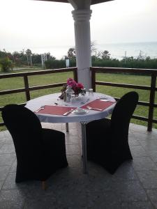 Ocean Villa Heights في بروفوت: طاولة مع كراسي سوداء وطاولة عليها زهور