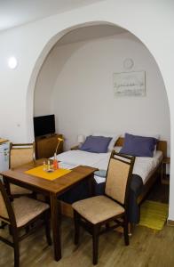 a bedroom with a bed and a table and chairs at Apartments Ozren in Soko Banja