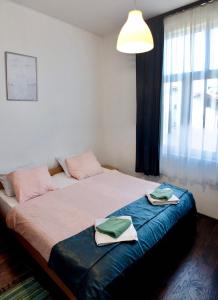 a bedroom with a bed with two towels on it at Apartments Ozren in Soko Banja
