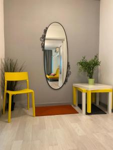 un miroir, deux tables et une chaise jaune dans l'établissement Green Apartment, à Bucarest