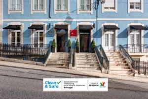 a blue building with stairs and a sign in front of it at Lx Boutique Hotel in Lisbon