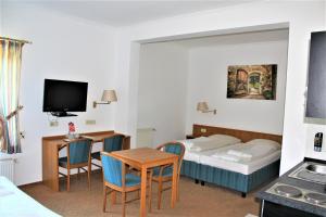 ヘンシュテット・ウルツブルクにあるHotel Alsterquelleのベッド、テーブル、椅子が備わるホテルルームです。