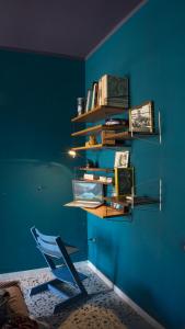 シラクーサにあるTraditional Sicily house design revisitedの青い壁の客室(椅子、本付)