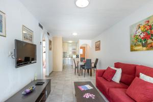 エンプリアブラバにあるApart-rent Apartment Sant Mori 0187のリビングルーム(赤いソファ、テーブル付)