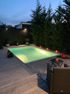 a swimming pool in a backyard with a wooden deck at La Dolce Villa - Maison 100m2 avec piscine chauffée de mi mai à mi oct en fonction du temps et température à Bordeaux Caudéran in Bordeaux