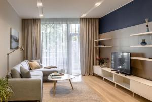 a living room with a couch and a tv at Osobnyak in Jūrmala