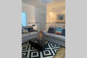 ein Wohnzimmer mit zwei Sofas und einem Tisch in der Unterkunft Eyemouth Home by the Harbour in Eyemouth