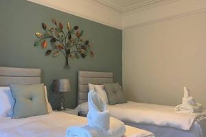 a bedroom with two beds and a painting on the wall at Eyemouth Home by the Harbour in Eyemouth