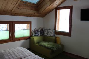 a bedroom with a green chair and a bed at Chalet Gädi in Zermatt