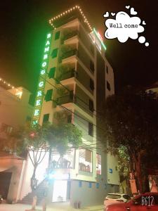 wysoki budynek z napisem "dobrze przyjdź" w obiekcie Bamboo Green Hotel w mieście Dong Hoi