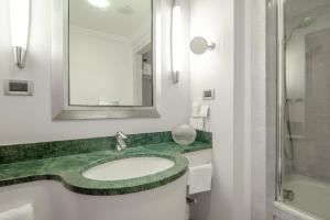 a bathroom with a sink and a mirror at Hotel Capo d´África – Colosseo in Rome