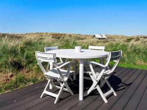 Slettestrandにある6 person holiday home in Brovstの白いテーブルと椅子が備わるデッキです。