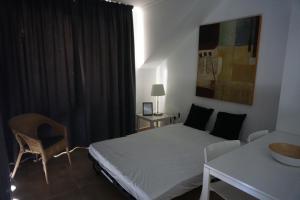 una camera con letto bianco, tavolo e sedia di Apartamento privado en Bahía Feliz a Playa del Aguila Altre 61 foto