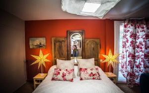 a bedroom with orange walls and a bed with pillows at Les chambres de Lily in Carresse