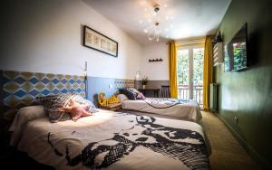 a bedroom with two beds with a baby laying on them at Les chambres de Lily in Carresse