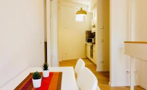 a living room with a white table with two plants on it at IL NIDO IN CENTRO in La Spezia