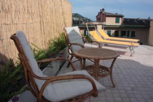 three chairs and a table on a patio at Hotel Cavour in Rapallo