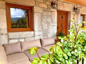 - un canapé installé devant un bâtiment en pierre avec une fenêtre dans l'établissement Naturbabia, à San Emiliano