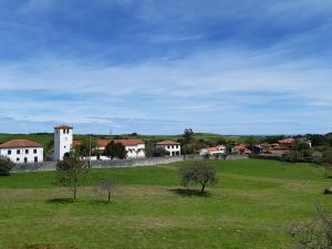 a green field with a building in the distance at Hotel Hontoria in Hontoria