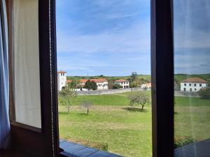 a window with a view of a field with houses at Hotel Hontoria in Hontoria