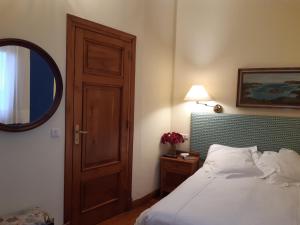 a bedroom with a bed with a wooden door and a mirror at Hotel Hontoria in Hontoria