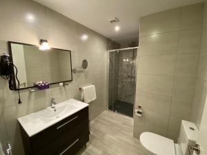 a bathroom with a sink and a shower and a toilet at Apartamentos La Ardina Celorio in Celorio +93 photos