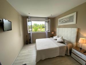 a small bedroom with a bed and a window at Apartamentos La Ardina Celorio in Celorio