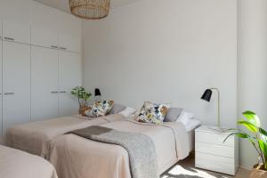 two beds in a room with white walls at SleepWell Apartments Itäkeskus, close to metro in Helsinki