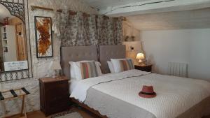 a bedroom with a bed with a hat on it at La Maison Colline in Saint-Émilion