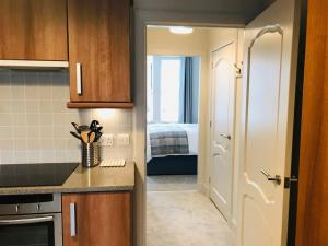 a small kitchen with a door leading to a bedroom at 3 Argyle Place in Dornoch