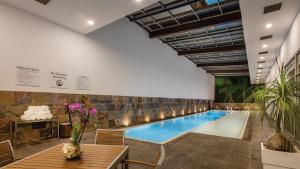 uma piscina num edifício com uma mesa e flores em Holiday Inn Express Puebla, an IHG Hotel em Puebla