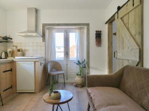 a living room with a couch and a table and a kitchen at Casa duna close to the beach, city centre, dunes and parking area in Zandvoort