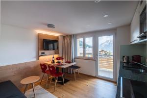 una cucina e un soggiorno con tavolo e sedie di Chalet Raufthubel a Mürren
