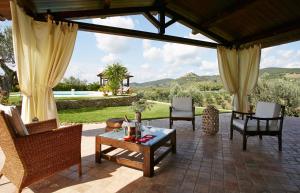 Holiday home with exclusive swimming pool in the Tuscan Maremma في Montemassi: فناء مع كراسي وطاولة مطلة