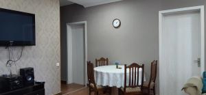 une salle à manger avec une table et une horloge murale dans l'établissement Dream House, à Mtskheta