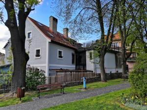 ein weißes Haus mit einem Baum und einer Bank in der Unterkunft Barbakan in Kremnitz