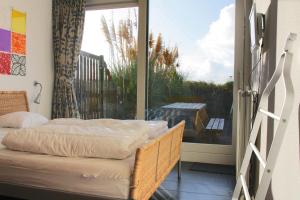 sypialnia z łóżkiem i dużym oknem w obiekcie Duinerei 2 w mieście Callantsoog