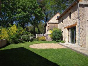 un jardin avec un bâtiment en pierre et une cour dans l'établissement Domaine des Marequiers Le Gite Asphodèle, à Saint-Germain-du-Teil