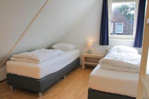 2 aparte bedden in een kamer met een raam bij Kruisweg 4 in Callantsoog